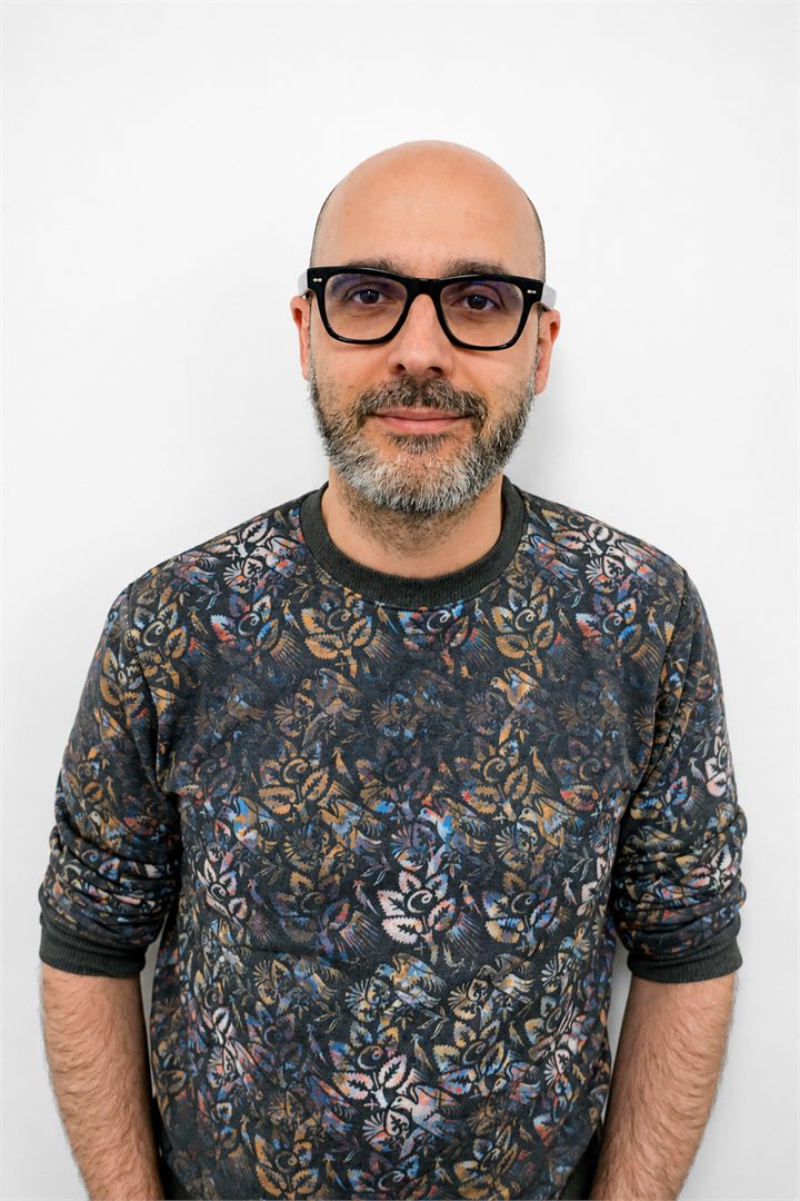 Portrait of Javier Gala wearing glasses and a patterned jumper.